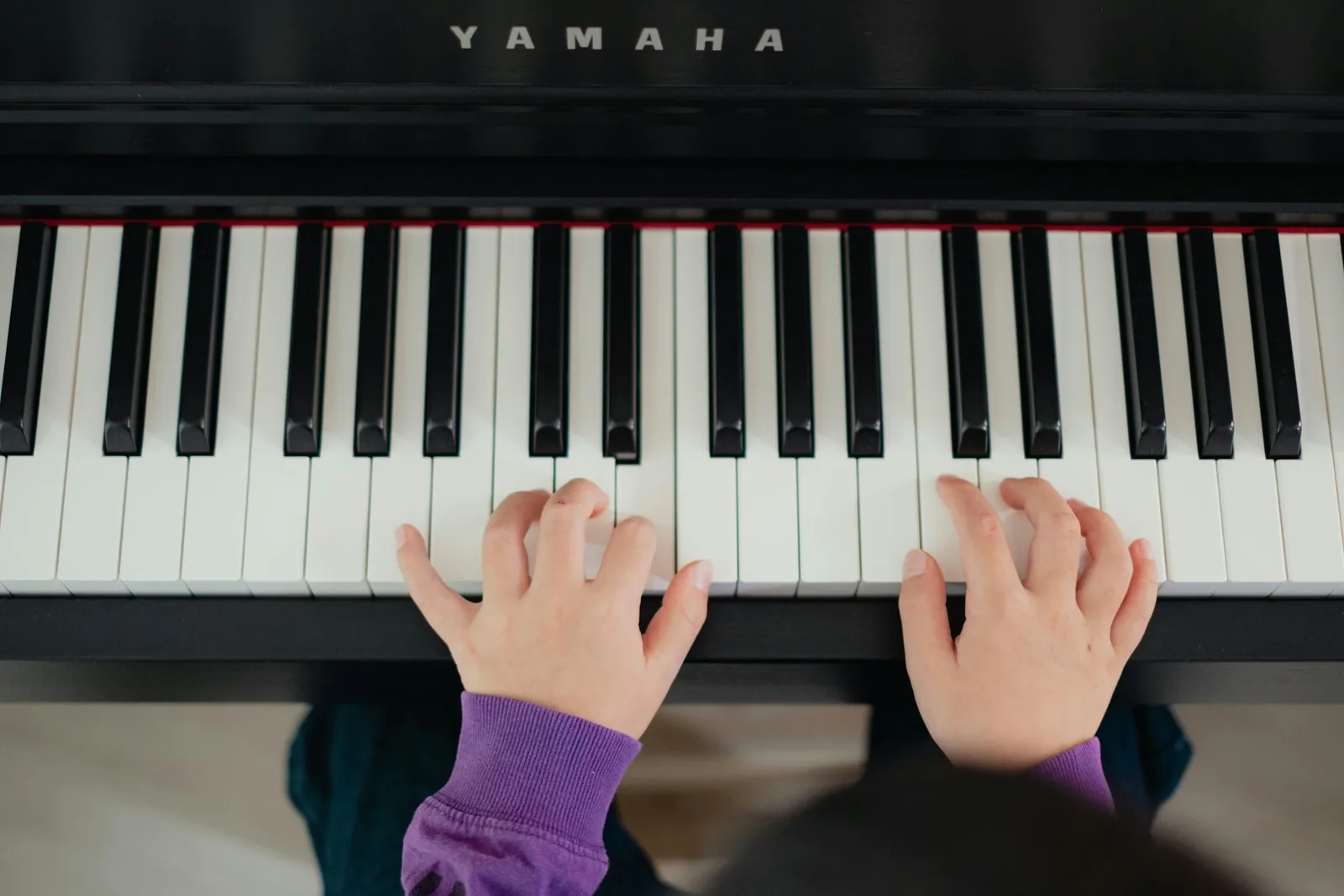 Mains d'enfant jouant sur un clavier de piano