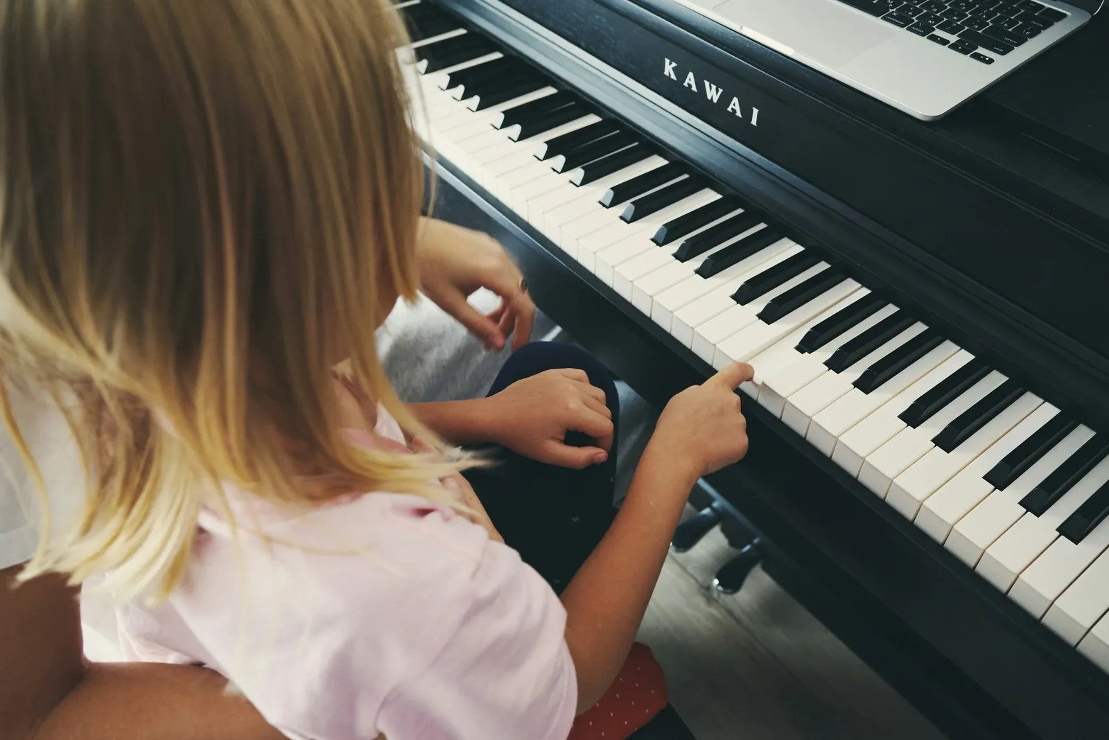 Enfant explorant les touches du piano à la maison