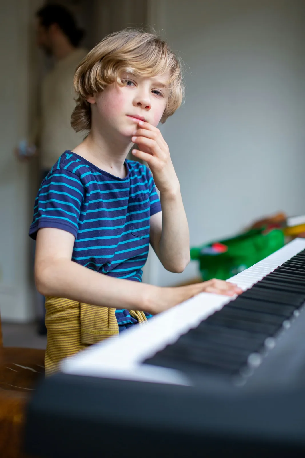 Jeune garçon assis pensivement au piano